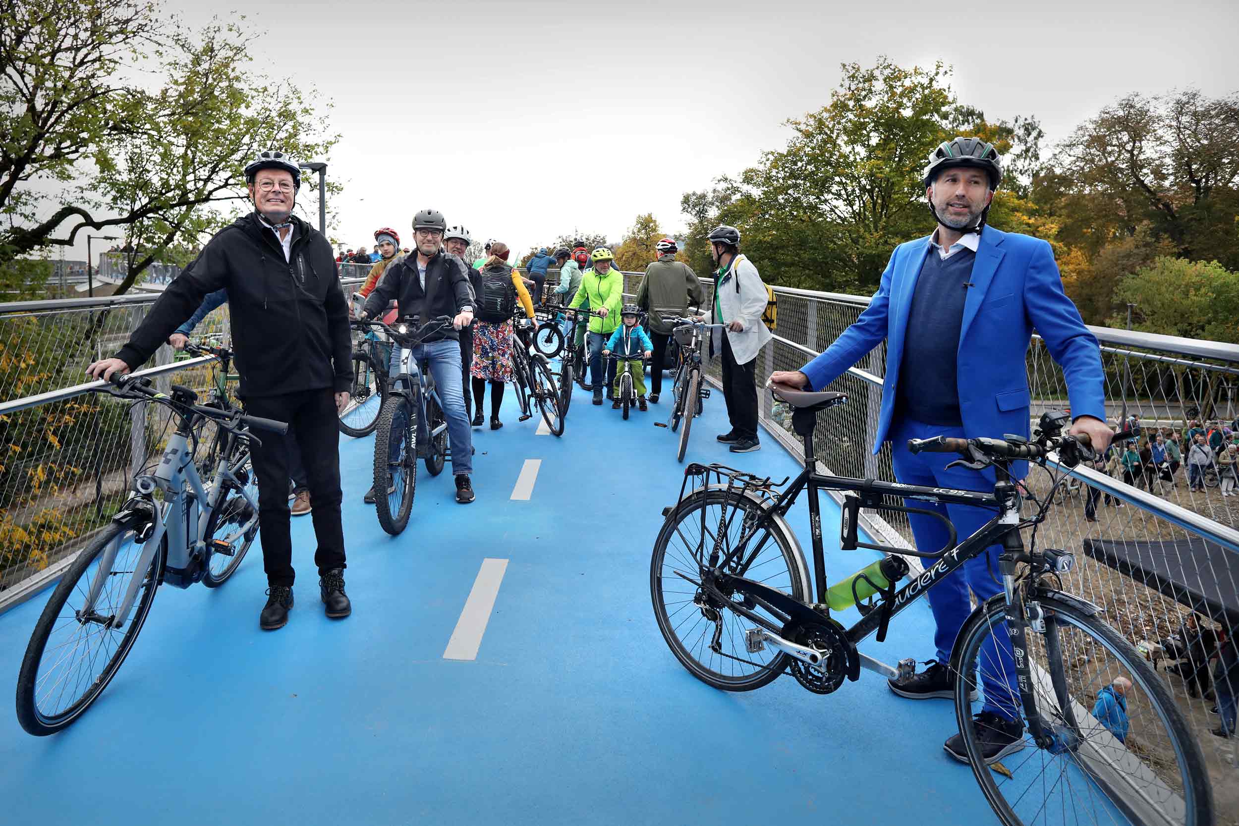 Oberbürgermeister boris palmer und regierungspräsident klaus tappeser zusammen mit zahlreichen zuschauer*innen bei der eröffnung der ann-arbor-brücke. Foto: anne faden