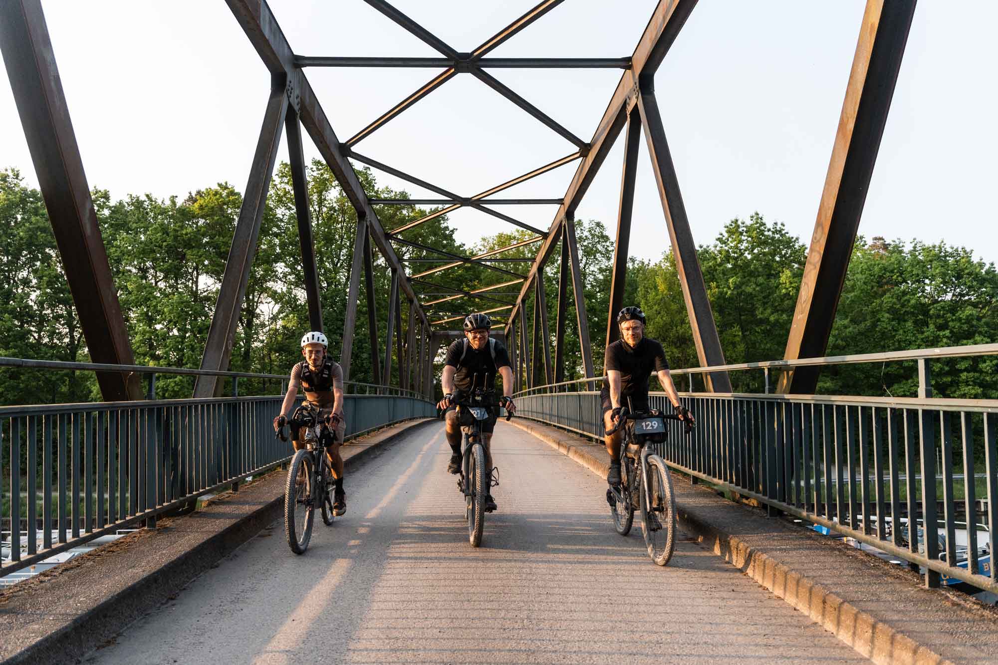 3 Gravelbiker fahren über eine Ruhrbrücke